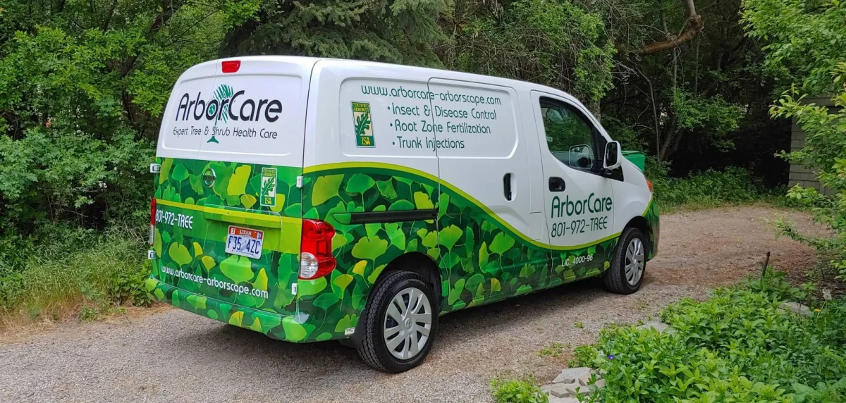 ArborCare's ginkgo-leaf wrapped service van with the ISA Certified Arborist seal and 801-972-TREE on the side